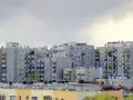 Bloki z cegły, dlaczego w 2026 roku mieszkania w blokach z cegły drożeją szybciej niż te z płyty? Szare, wielopiętrowe budynki mieszkalne z balkonami.
