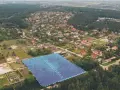 Działki bez planu ogólnego gminy będą niesprzedawalne od lipca 2026. Aerial view of suburban housing development with a highlighted plot of land.