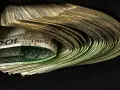 Stos polskich banknotów 100 zł w czarnym tle.