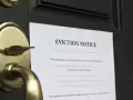 Zawiadomienie o eksmisji na drzwiach. Lokator nie płaci czynszu, co w 2026 roku oznacza prawdziwe koszty eksmisji.