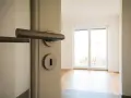 Otwarcie drzwi do pustego mieszkania. Zastanawiasz się, ile kosztuje kawalerka w Niemczech?