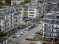 Nowy blok mieszkalny z balkonami i samochodami na parkingu. Kto musi zapłacić 64 tysiące złotych kary za uchylanie się od podatku od nieruchomości?