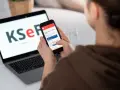 Kobieta sprawdza na telefonie informacje o KSeF, co może być związane z tym, dlaczego od 2026 roku najemcy coraz częściej żądają faktur VAT za mieszkanie.
