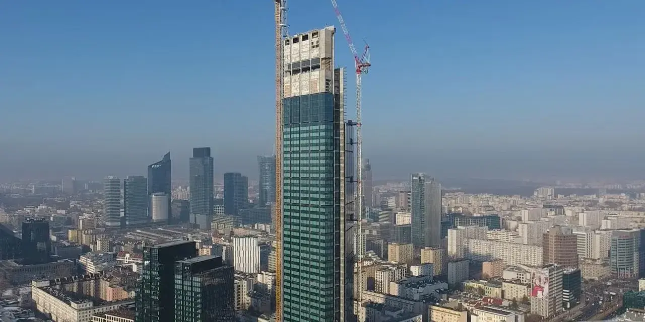 Varso Tower w budowie, z dźwigami na szczycie, góruje nad panoramą Warszawy. Trudno ocenić, ile pięter ma Varso Tower, ale jest już najwyższym budynkiem w Polsce.