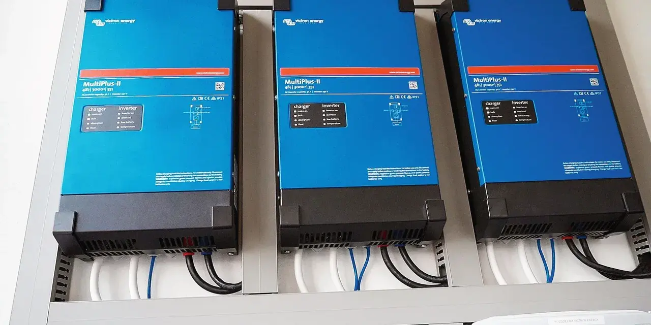 Trzy niebieskie falowniki Victron Energy MultiPlus-II zamontowane obok siebie. Od września 2026 r. każdy blok musi posiadać certyfikowany magazyn energii.