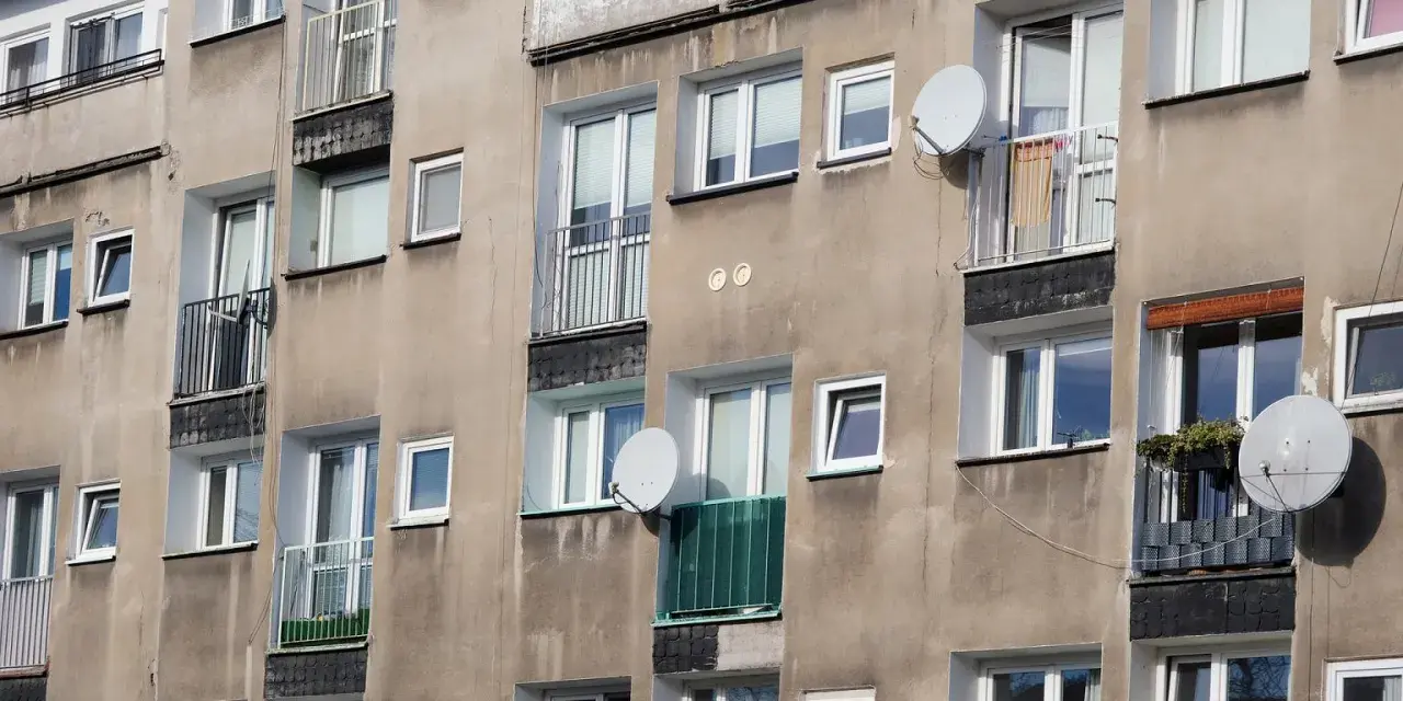 Szare bloki mieszkalne z balkonami i antenami satelitarnymi. Czy wojsko daje mieszkanie w takich budynkach?