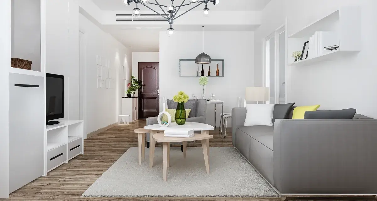 Nowe przepisy Airbnb: dlaczego od 20 maja 2026 r. każdy lokal musi mieć numer rejestracyjny? Nowoczesny salon z szarą kanapą i stolikami kawowymi.