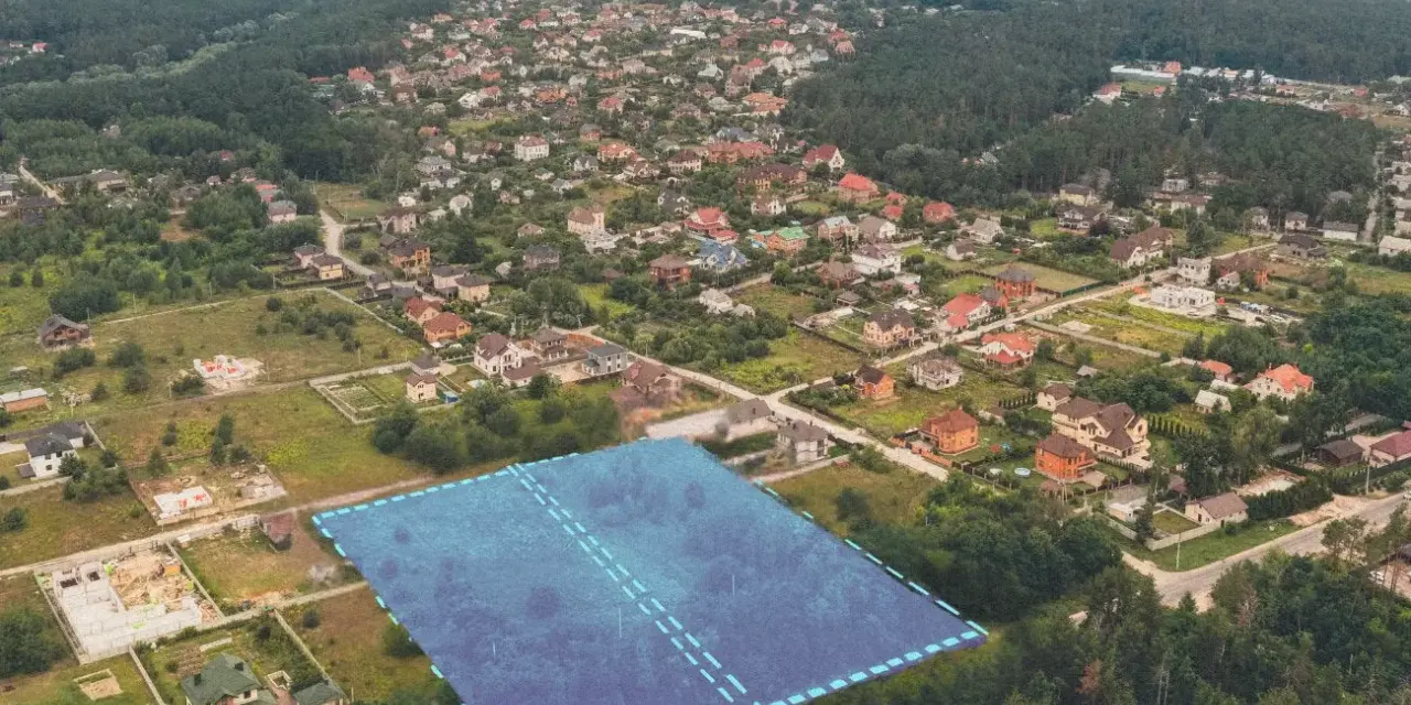 Działki bez planu ogólnego gminy będą niesprzedawalne od lipca 2026. Aerial view of suburban housing development with a highlighted plot of land.