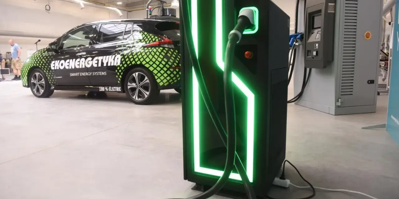 Elektryczny samochód "Ekoenergetyka" przy nowoczesnej ładowarce. Od września 2026 r. każdy blok musi mieć punkt ładowania aut elektrycznych.