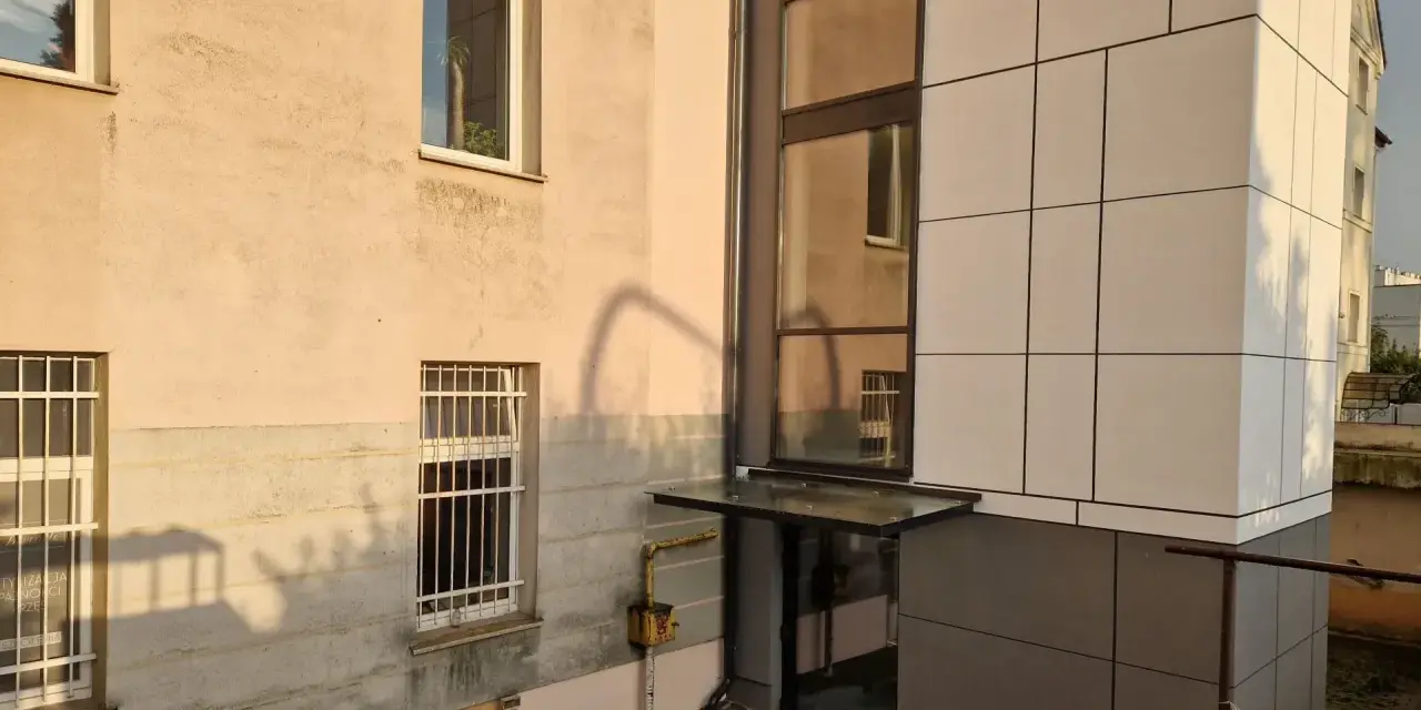 Nowoczesna elewacja bloku z nową windą zewnętrzną. Dowiedz się, ile kosztuje wymiana windy w bloku.
