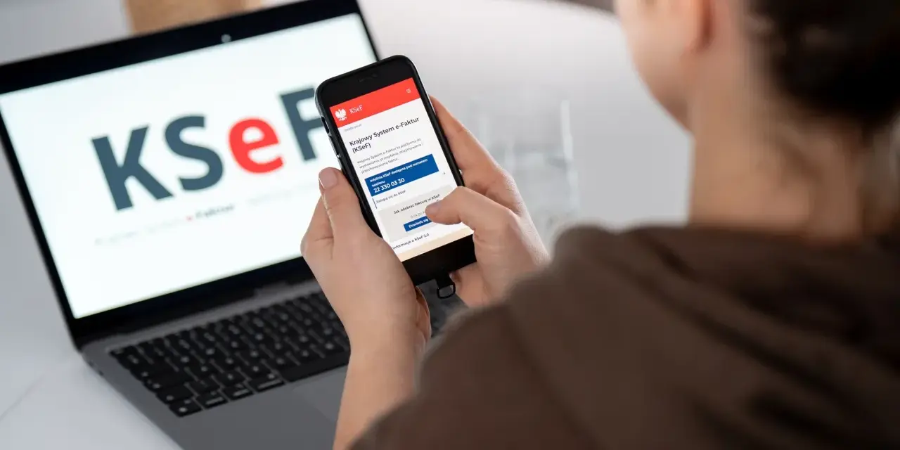 Kobieta sprawdza na telefonie informacje o KSeF, co może być związane z tym, dlaczego od 2026 roku najemcy coraz częściej żądają faktur VAT za mieszkanie.