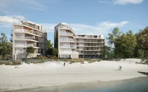 Nowoczesne apartamenty nad morzem, które mogą stracić na wartości od 2026 roku. Widok na plażę i budynki z balkonami.