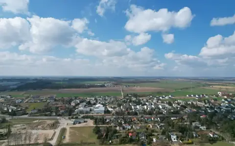 Krajobraz z zabudowaniami i polami. Działki rolne z możliwością zabudowy zagrodowej są teraz najbardziej poszukiwane, bo łączą spokój wsi z potencjałem rozwoju.