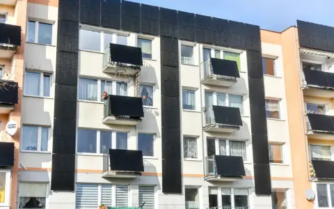 Prawdziwa historia bloku, który zaczął się przechylać po wykopach pod sąsiednią inwestycję. Widok na fasadę budynku z balkonami i oknami.