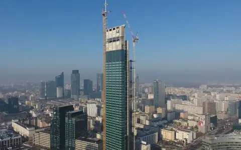 Varso Tower w budowie, z dźwigami na szczycie, góruje nad panoramą Warszawy. Trudno ocenić, ile pięter ma Varso Tower, ale jest już najwyższym budynkiem w Polsce.