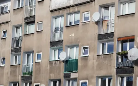 Szare bloki mieszkalne z balkonami i antenami satelitarnymi. Czy wojsko daje mieszkanie w takich budynkach?
