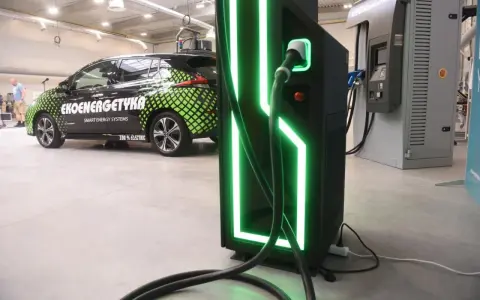 Elektryczny samochód "Ekoenergetyka" przy nowoczesnej ładowarce. Od września 2026 r. każdy blok musi mieć punkt ładowania aut elektrycznych.