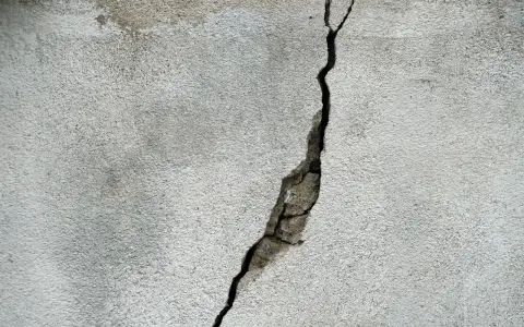 Pęknięcie na betonowej ścianie, które może wskazywać na ukryte przyczyny pękania ścian w blokach oddanych do użytku po 2024 roku.