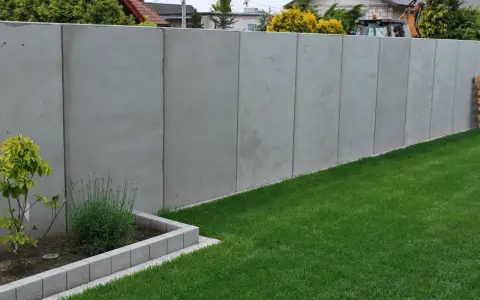 Betonowy mur wysoki na 2,2m. Unikaj najgorszych błędów przy zgłaszaniu budowy ogrodzenia powyżej 2,2 metra po nowym prawie.