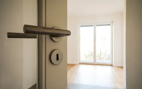 Otwarcie drzwi do pustego mieszkania. Zastanawiasz się, ile kosztuje kawalerka w Niemczech?