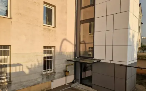 Nowoczesna elewacja bloku z nową windą zewnętrzną. Dowiedz się, ile kosztuje wymiana windy w bloku.