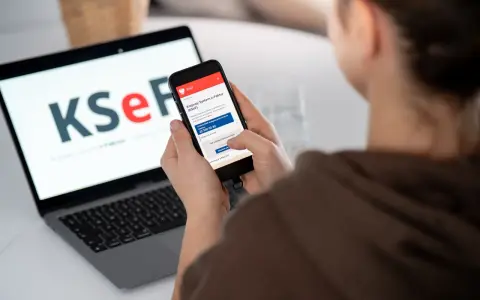 Kobieta sprawdza na telefonie informacje o KSeF, co może być związane z tym, dlaczego od 2026 roku najemcy coraz częściej żądają faktur VAT za mieszkanie.