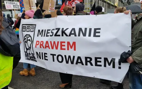 Protestujący niosą transparent "Mieszkanie prawem nie towarem!", domagając się ustaw chroniących lokatorów.