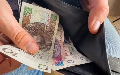 Ręka wyciąga polskie banknoty z portfela. Czy to wyjaśnia, dlaczego w marcu 2026 r. limity dochodowe do dodatku mieszkaniowego wzrosły o 20 proc.?