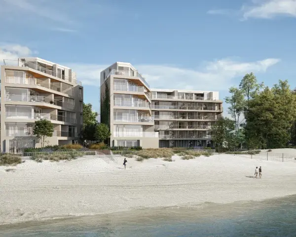 Nowoczesne apartamenty nad morzem, które mogą stracić na wartości od 2026 roku. Widok na plażę i budynki z balkonami.