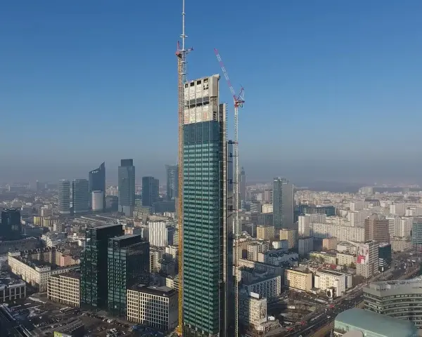 Varso Tower w budowie, z dźwigami na szczycie, góruje nad panoramą Warszawy. Trudno ocenić, ile pięter ma Varso Tower, ale jest już najwyższym budynkiem w Polsce.