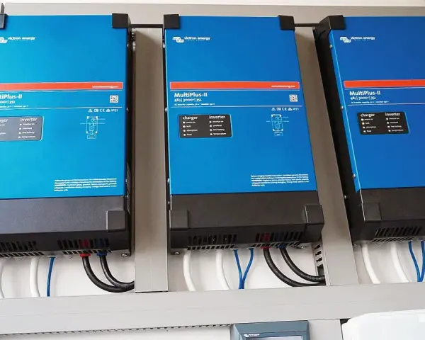 Trzy niebieskie falowniki Victron Energy MultiPlus-II zamontowane obok siebie. Od września 2026 r. każdy blok musi posiadać certyfikowany magazyn energii.