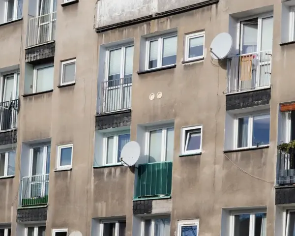 Szare bloki mieszkalne z balkonami i antenami satelitarnymi. Czy wojsko daje mieszkanie w takich budynkach?
