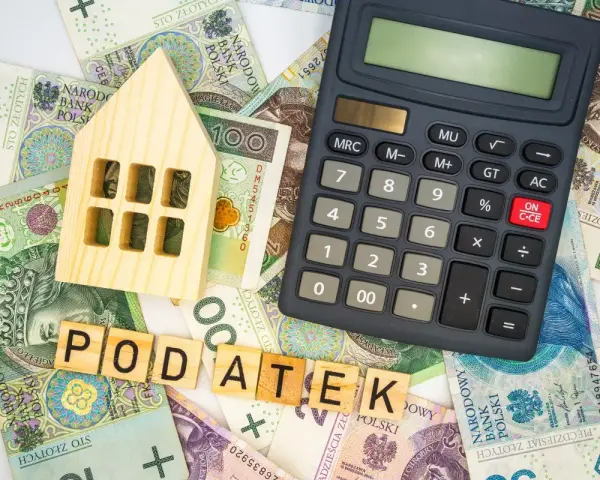 Drewniany domek, kalkulator i polskie banknoty. Czy podatek od nieruchomości za grunt wzrośnie o maksymalną stawkę 4,5 procent?