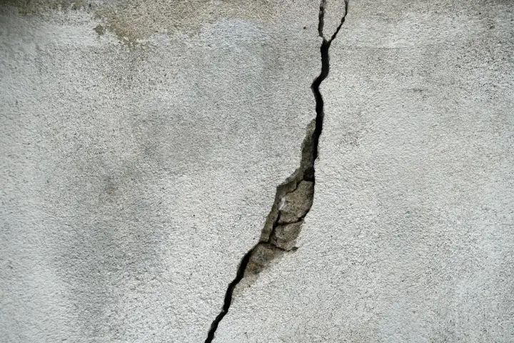 Pęknięcie na betonowej ścianie, które może wskazywać na ukryte przyczyny pękania ścian w blokach oddanych do użytku po 2024 roku.