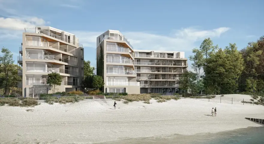 Nowoczesne apartamenty nad morzem, które mogą stracić na wartości od 2026 roku. Widok na plażę i budynki z balkonami.