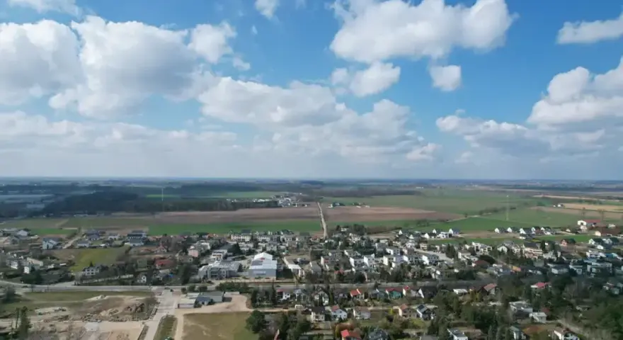 Krajobraz z zabudowaniami i polami. Działki rolne z możliwością zabudowy zagrodowej są teraz najbardziej poszukiwane, bo łączą spokój wsi z potencjałem rozwoju.