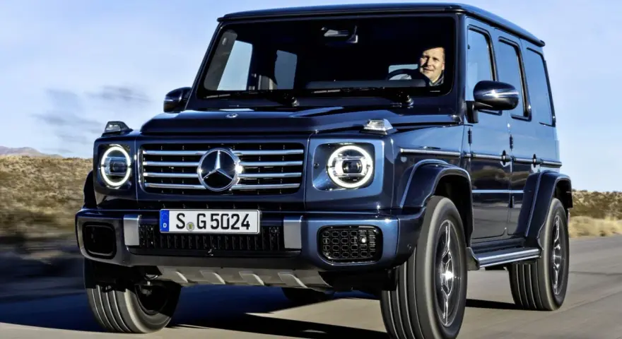 Ciemnoniebieski Mercedes-Benz Klasy G z kierowcą za kierownicą, jadący po pustynnej drodze. Czy mieszkania w klasie energetycznej G staną się niesprzedawalne po czerwcu 2026?