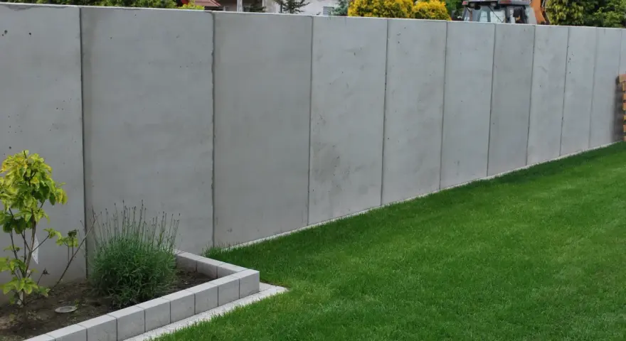 Betonowy mur wysoki na 2,2m. Unikaj najgorszych błędów przy zgłaszaniu budowy ogrodzenia powyżej 2,2 metra po nowym prawie.