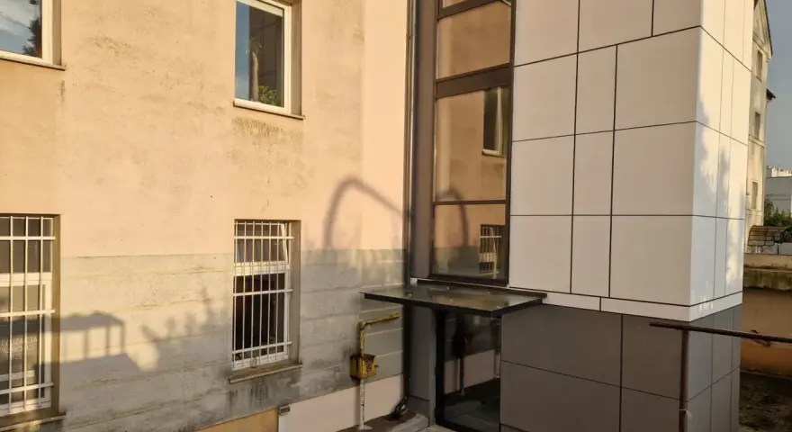 Nowoczesna elewacja bloku z nową windą zewnętrzną. Dowiedz się, ile kosztuje wymiana windy w bloku.