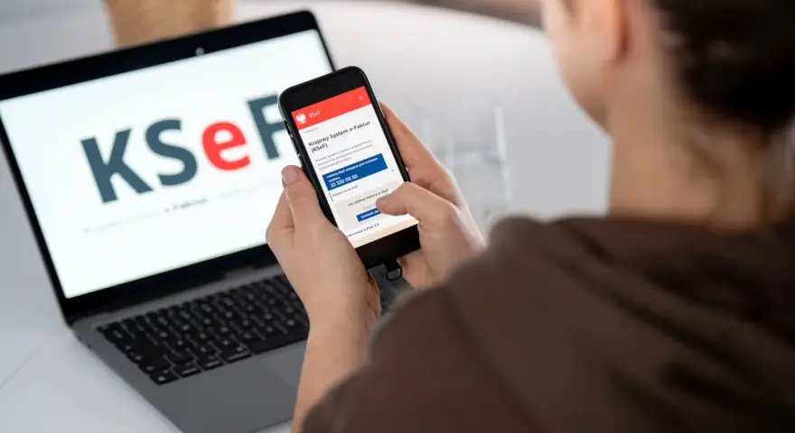 Kobieta sprawdza na telefonie informacje o KSeF, co może być związane z tym, dlaczego od 2026 roku najemcy coraz częściej żądają faktur VAT za mieszkanie.