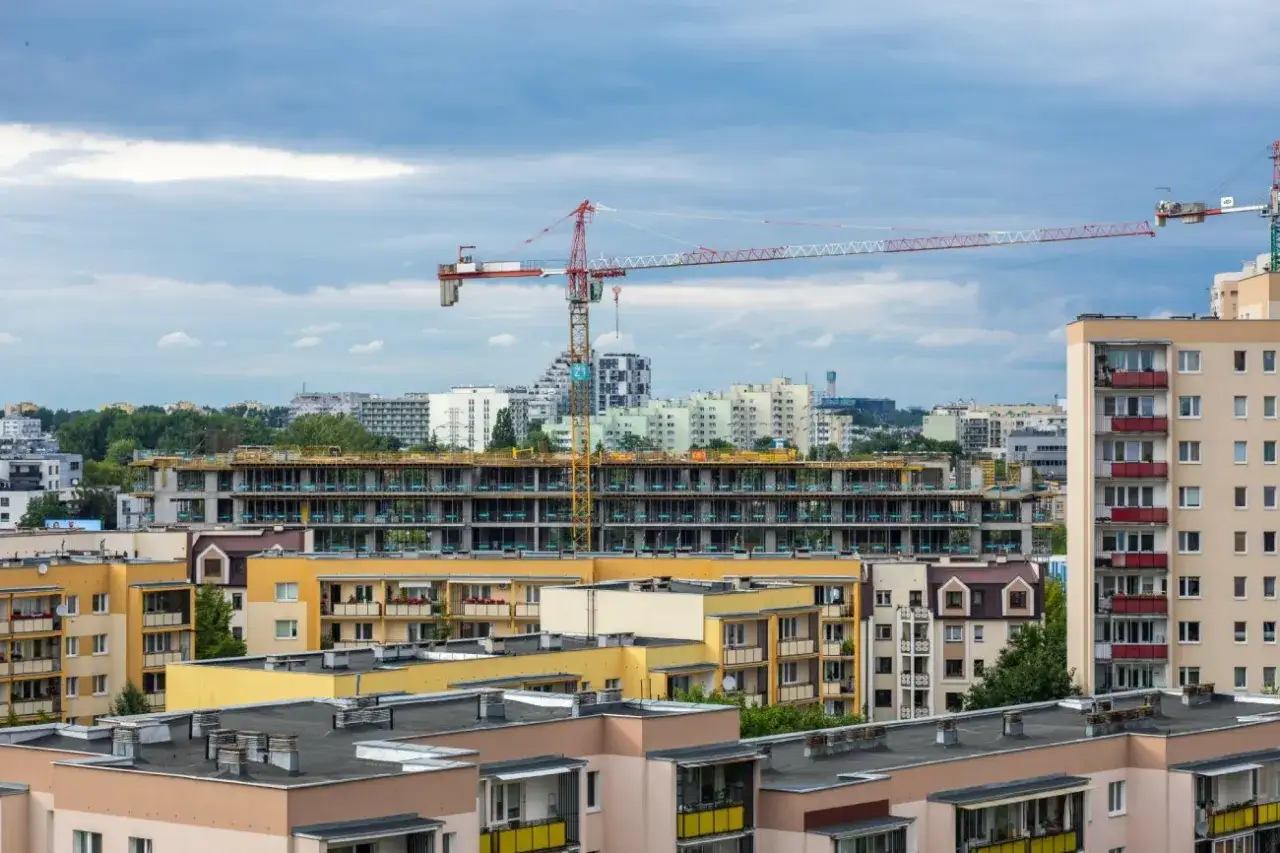 Budowa osiedla, gdzie kto stoi za nowym systemem dopłat do kredytów 0% i dlaczego projekt utknął, widać na tle pochmurnego nieba.