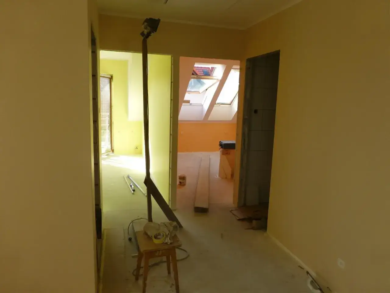 Wnętrze w trakcie remontu, widok na korytarz i pokoje. Może to być powód, dlaczego znany deweloper został pozwany za ukryte wady instalacji w całym bloku.