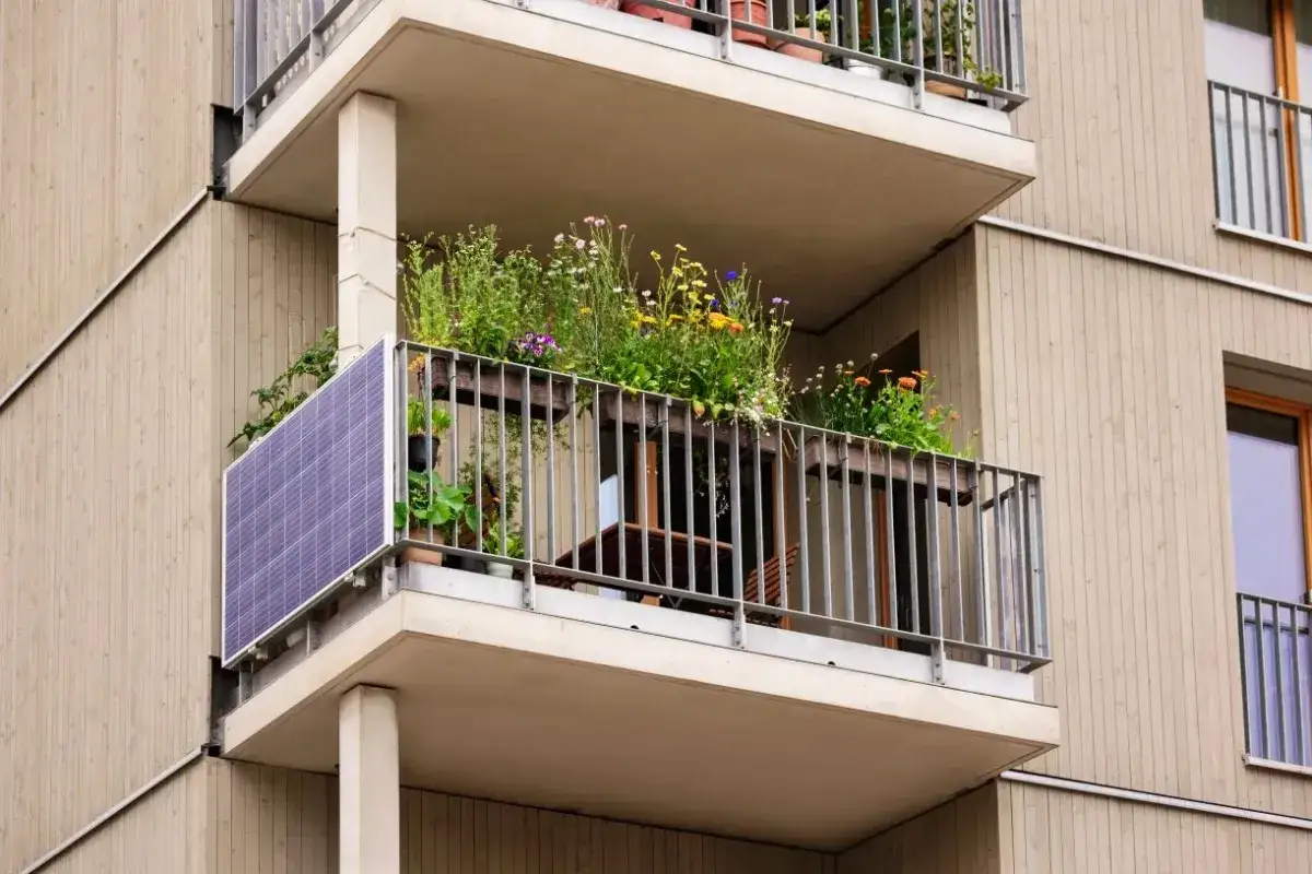 Balkon z kwiatami i panelem słonecznym. Kto stoi za nową ustawą o własności lokali i zmianami w zarządzaniu balkonami?