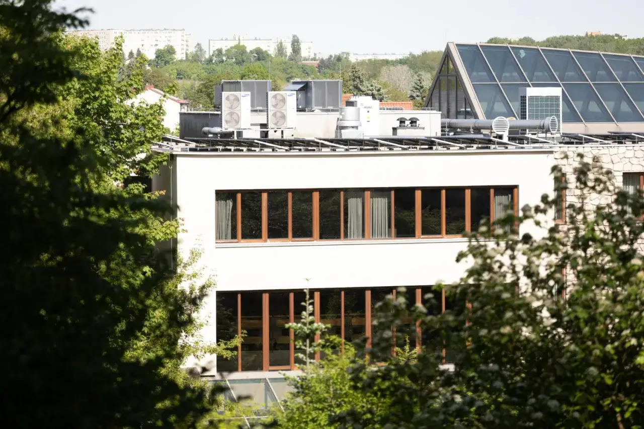 Nowe budynki od września 2026 będą musiały mieć instalację fotowoltaiczną. Na dachu widać panele i klimatyzatory.