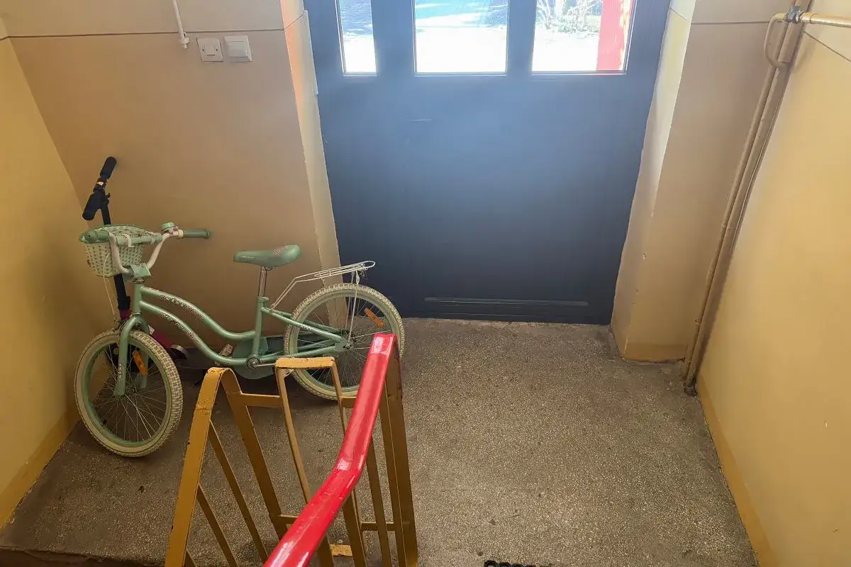 Dziecięcy rower stoi na klatce schodowej, co może być powodem, dlaczego wspólnoty mieszkaniowe ograniczają dostęp do wózkowni i piwnic.