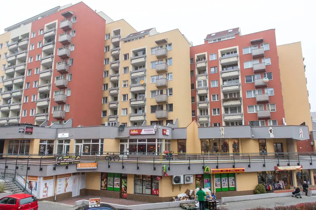 Bloki z cegły, dlaczego w 2026 roku mieszkania w blokach z cegły drożeją szybciej niż te z płyty? Nowoczesne budynki mieszkalne z balkonami i lokalami usługowymi na parterze.