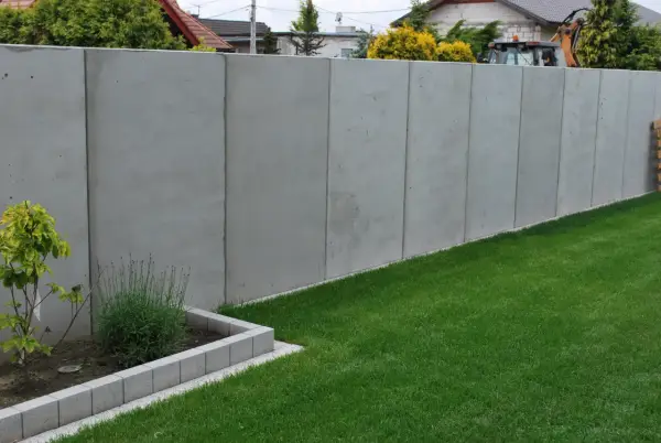 Betonowy mur wysoki na 2,2m. Unikaj najgorszych błędów przy zgłaszaniu budowy ogrodzenia powyżej 2,2 metra po nowym prawie.